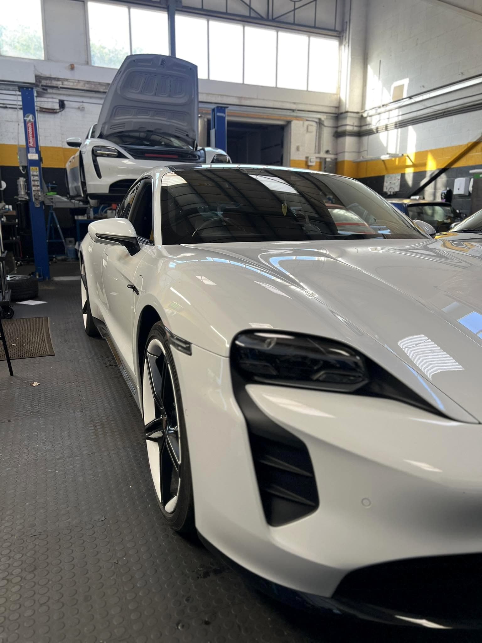 Porsche Taycan and Porsche Cayman inside SG Porsche Specialists workshop in Leicester